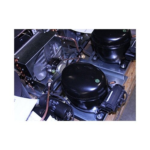 A close-up of a black True condensing unit with a white label on a black cylinder.
