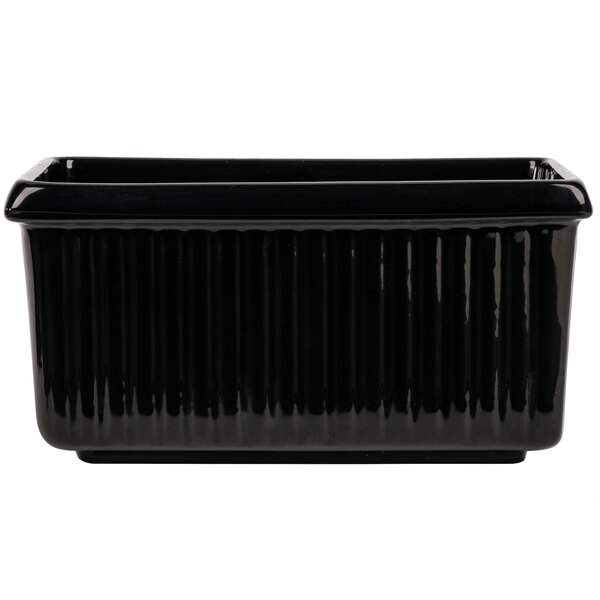 A black rectangular Tablecraft server with ridges on a counter in a salad bar.