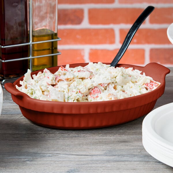 A Tablecraft copper casserole dish filled with food on a table.