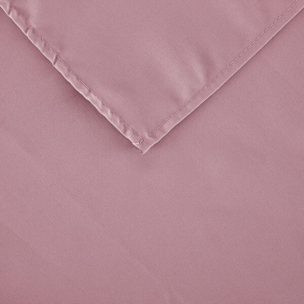 A white rectangular table with a pink hemmed cloth table cover on the corner.