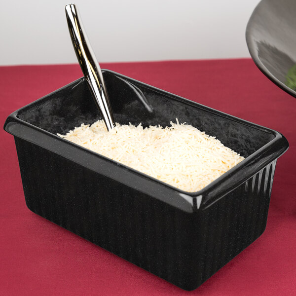 A black Tablecraft rectangle server with white rice and a spoon.