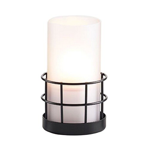 A white candle in a black metal holder.