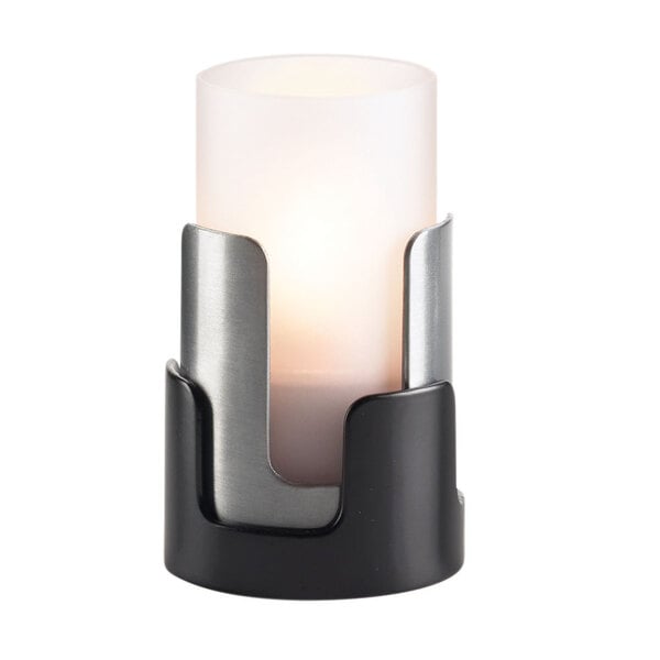 A close-up of a Sterno frost lamp cylinder globe over a candle.