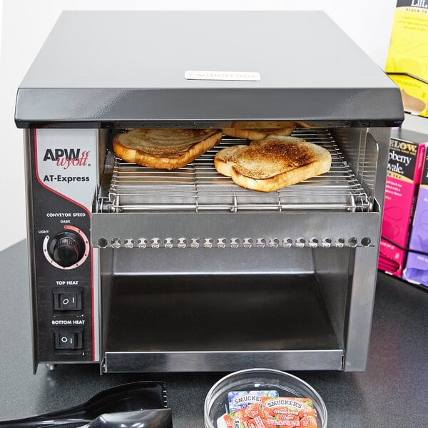 An APW Wyott conveyor toaster toasting bread.