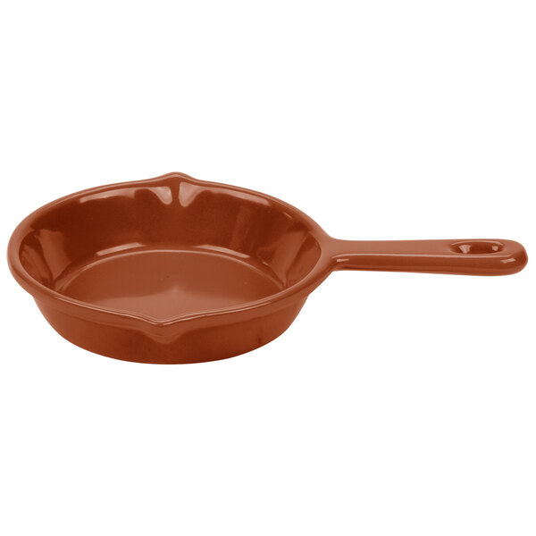 A brown cast aluminum fry pan with a handle.