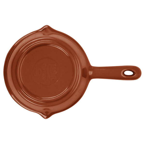 A brown cast aluminum fry pan with a handle.
