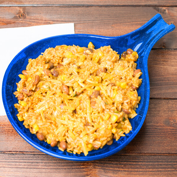 A blue Tablecraft skillet filled with rice and beans on a table in a Mexican restaurant.