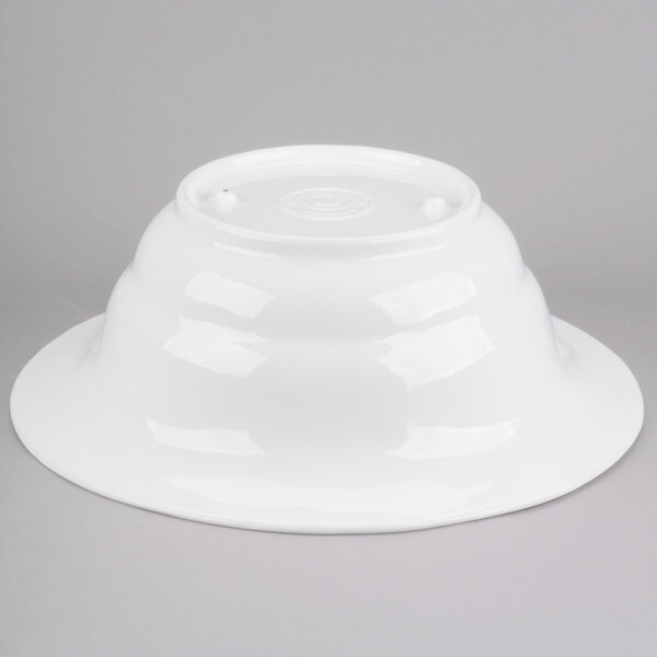 A white Tablecraft cast aluminum salad bowl on a gray surface.