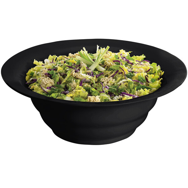 A Tablecraft black cast aluminum wide rim salad bowl filled with salad on a white background.