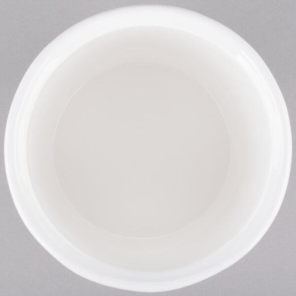 A white Tablecraft cast aluminum salad dressing bowl with a lid on a gray surface.