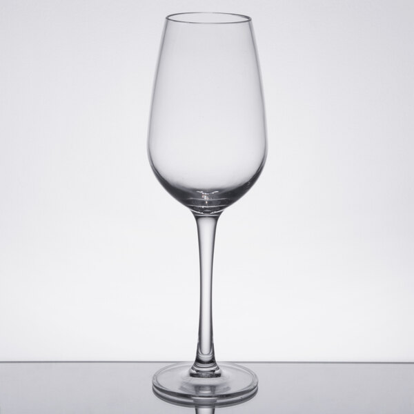 A clear Thunder Group plastic wine glass on a reflective surface.