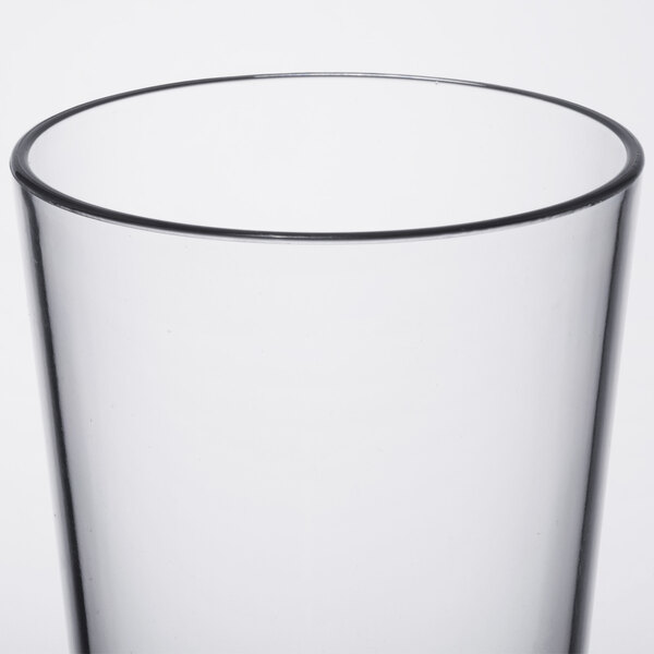 A clear plastic mixing glass with a black rim.