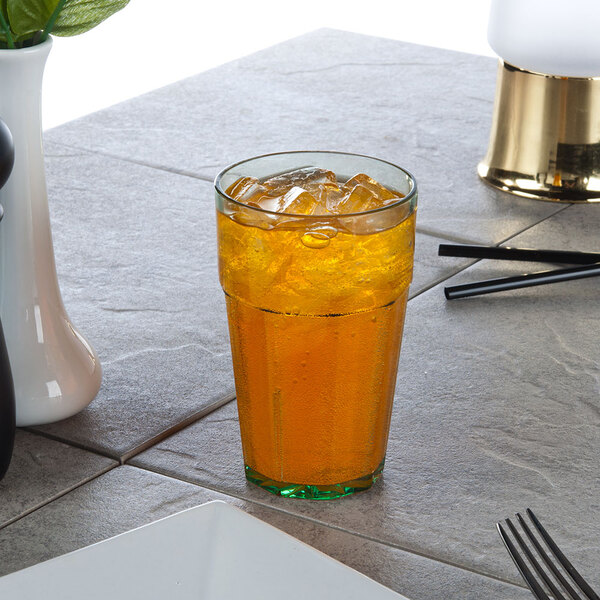 A green Thunder Group Diamond plastic tumbler filled with ice tea on a table.