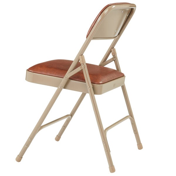 A National Public Seating beige metal folding chair with a brown cushion.
