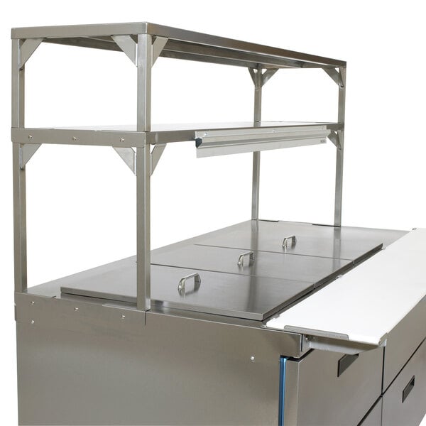 A stainless steel kitchen counter with a Delfield stainless steel double overshelf.
