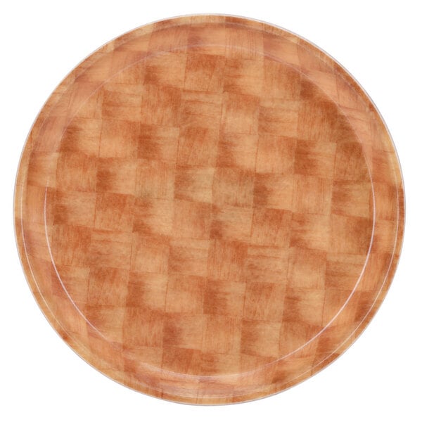 A Cambro round fiberglass tray with a light basketweave pattern on a wooden surface.