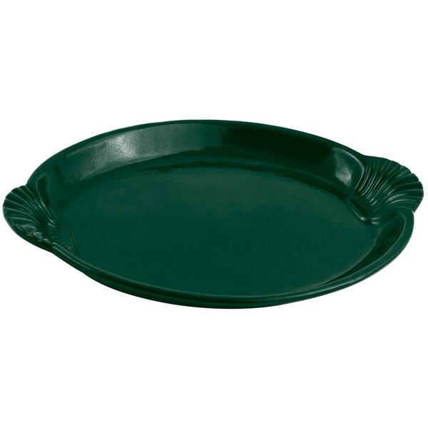 A Bon Chef hunter green cast aluminum tray with a scalloped edge shaped like a shell.