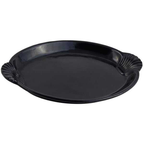 A black cast aluminum tray with a scalloped shell and fish design.