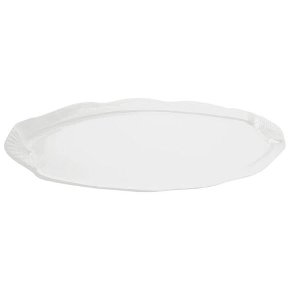 A white cast aluminum platter with a scalloped edge decorated with shells and fish.