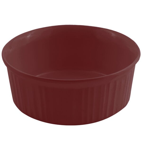 A red round Bon Chef casserole dish with a lid on a white surface.