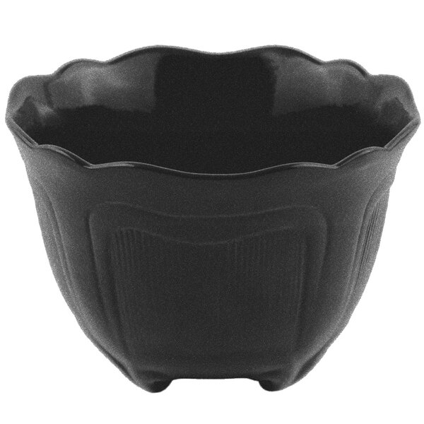 A black Bon Chef cast aluminum garnish bowl with a wavy edge.