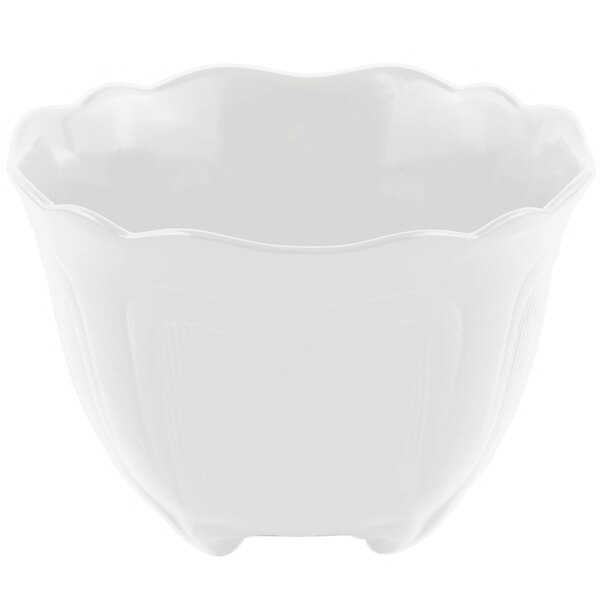 A white bowl with a scalloped edge and a small handle.