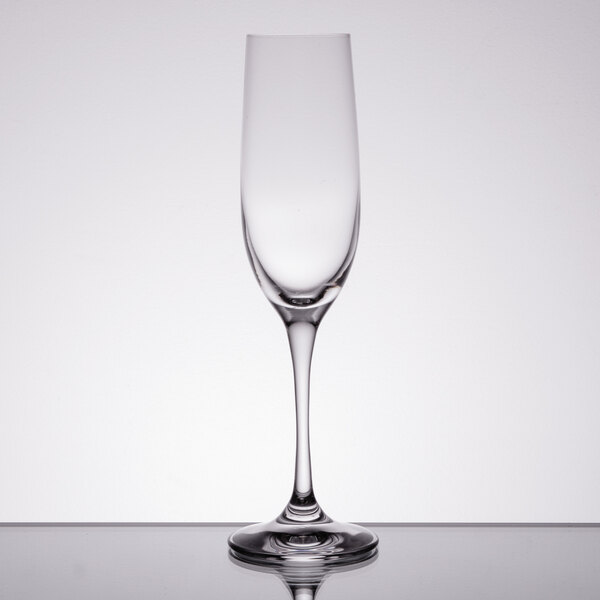 A close-up of a Spiegelau Vino Grande flute glass on a reflective surface.