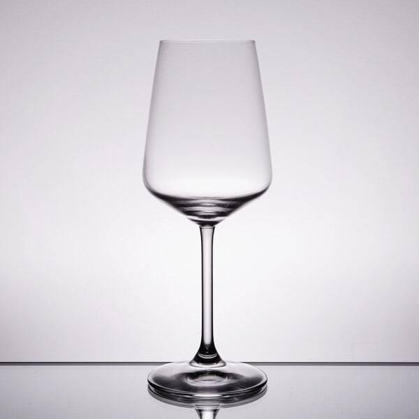 A Spiegelau white wine glass on a reflective surface.