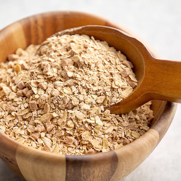 A bowl of Natural Cinnamon Apple Oatmeal with a wooden spoon.