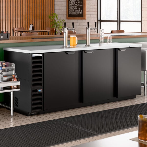 A large black double tap kegerator beer dispenser with three doors and a stainless steel top, designed to hold up to five half kegs.