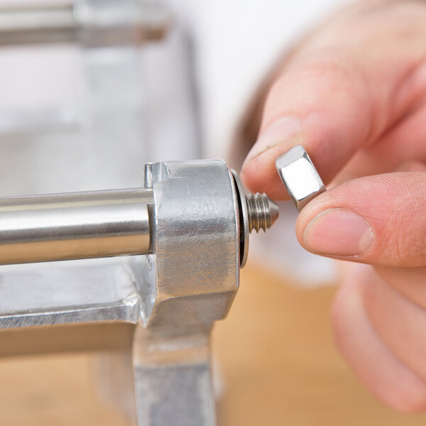 A hand holding a Nemco Guide Rod for a French Fry Cutter.