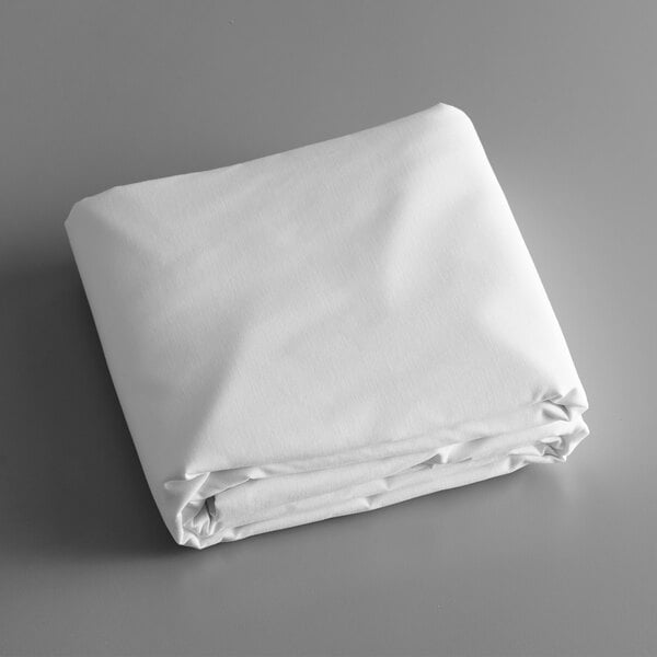 A folded white Intedge tablecloth on a gray surface.