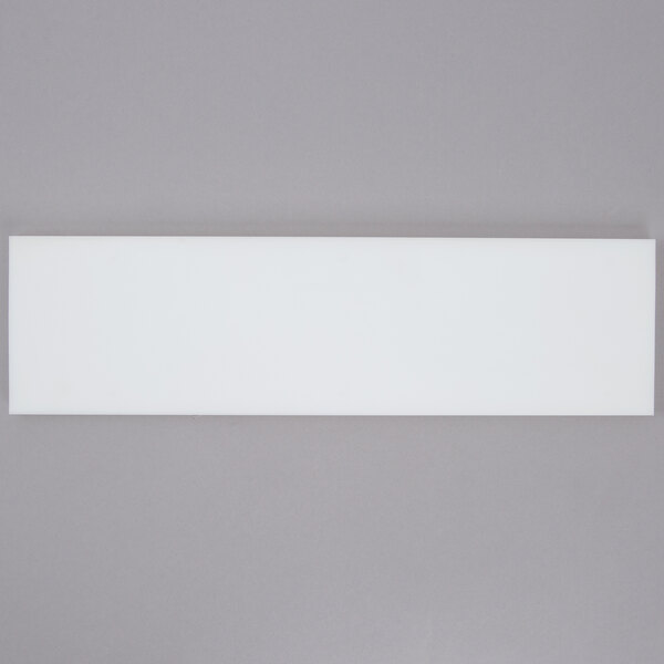 A white rectangular object with a black border on a gray surface.