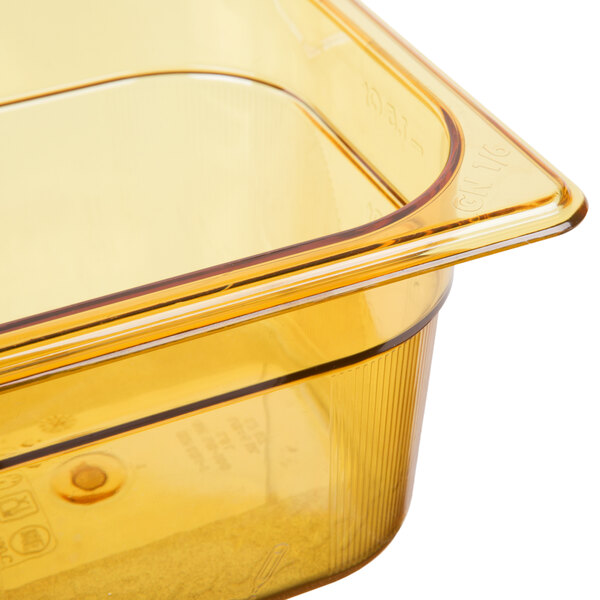 A Rubbermaid amber plastic food pan on a counter.