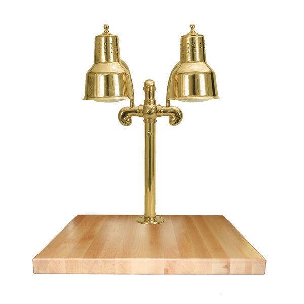 A brass Hanson Heat Lamp on a wooden surface with a maple block and gravy lane.