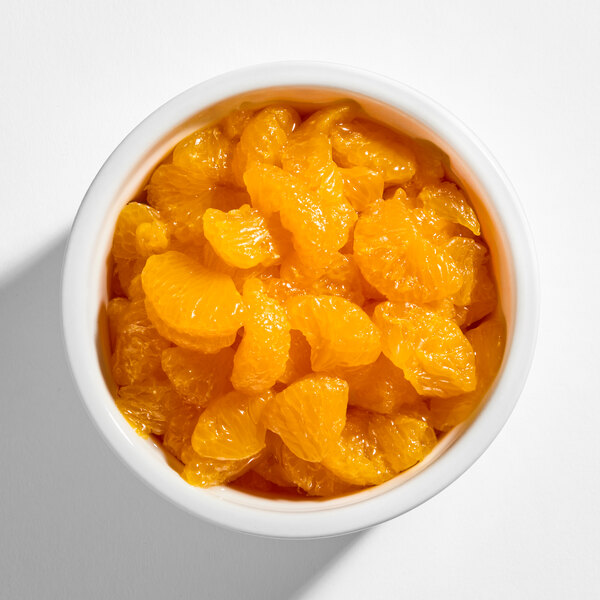 A white bowl filled with bright orange mandarin orange segments.
