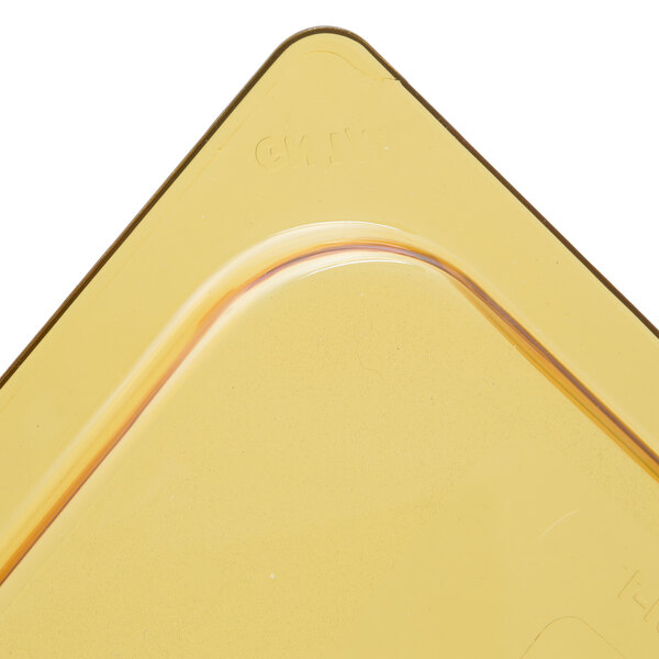 A yellow plastic Rubbermaid lid with notches and a handle.