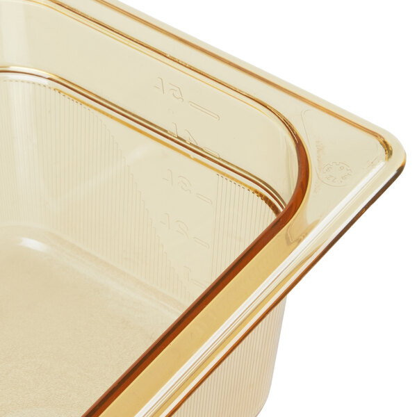 A Rubbermaid amber plastic food pan with a lid on a counter.