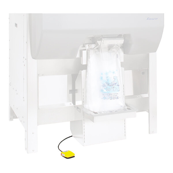 A yellow foot pedal connected by a black cord, positioned on the floor near a large ice dispensing machine.