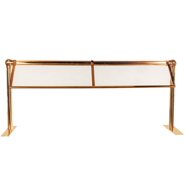 A Hanson Heat Lamps double-sided sneeze guard with gold metal bars and glass panels on a table.