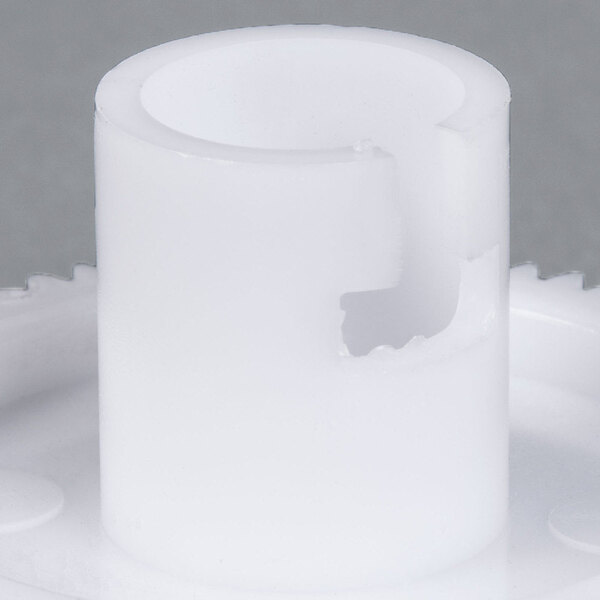 A white plastic gear with a hole in it.