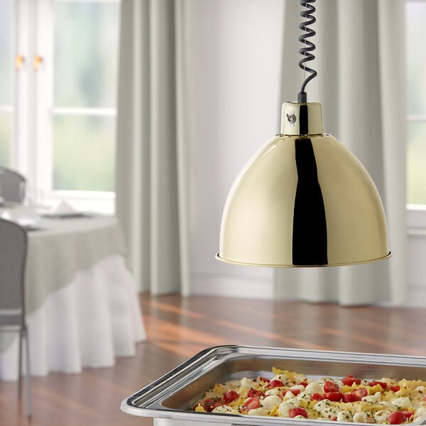 A Hanson Heat Lamp with a brass finish retracted over a table of food in a hotel buffet.