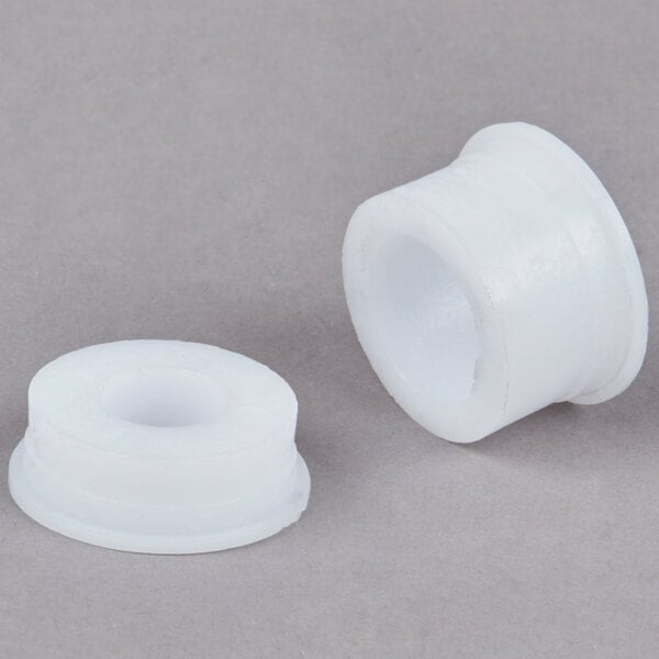 A close-up of a pair of white plastic bushings.
