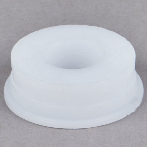 A white round plastic bearing with a hole in it.