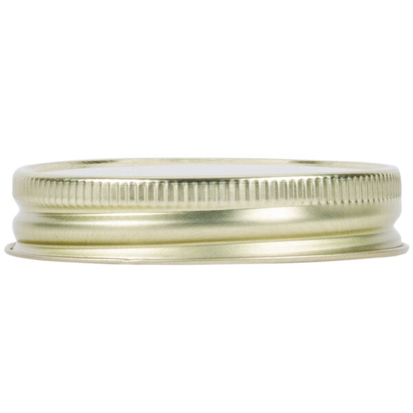 A close-up of a Libbey gold metal Mason jar lid with a metal rim.