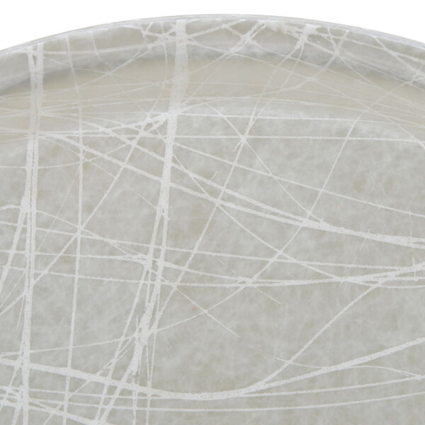 A Cambro round gray fiberglass tray with a crack pattern.