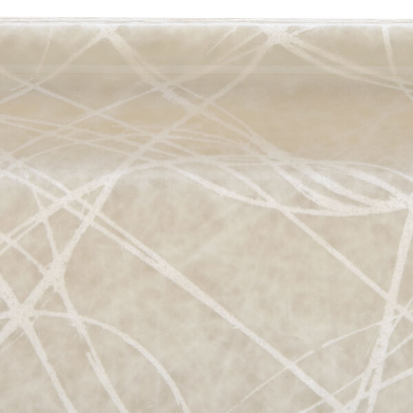 A close-up of a white square Cambro tray with a tan abstract design.