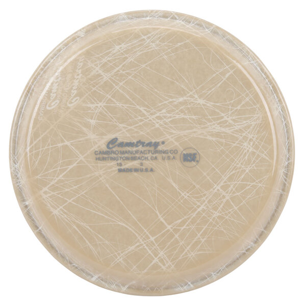 A round tan Cambro fiberglass tray with a white abstract design.