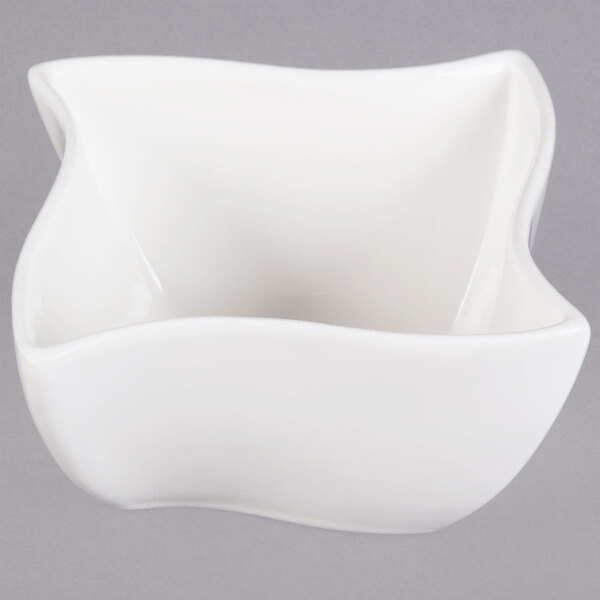 An American Metalcraft Prestige white porcelain bowl with a curved wave edge.