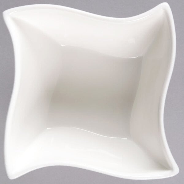 An American Metalcraft Prestige white porcelain bowl with a wavy edge.
